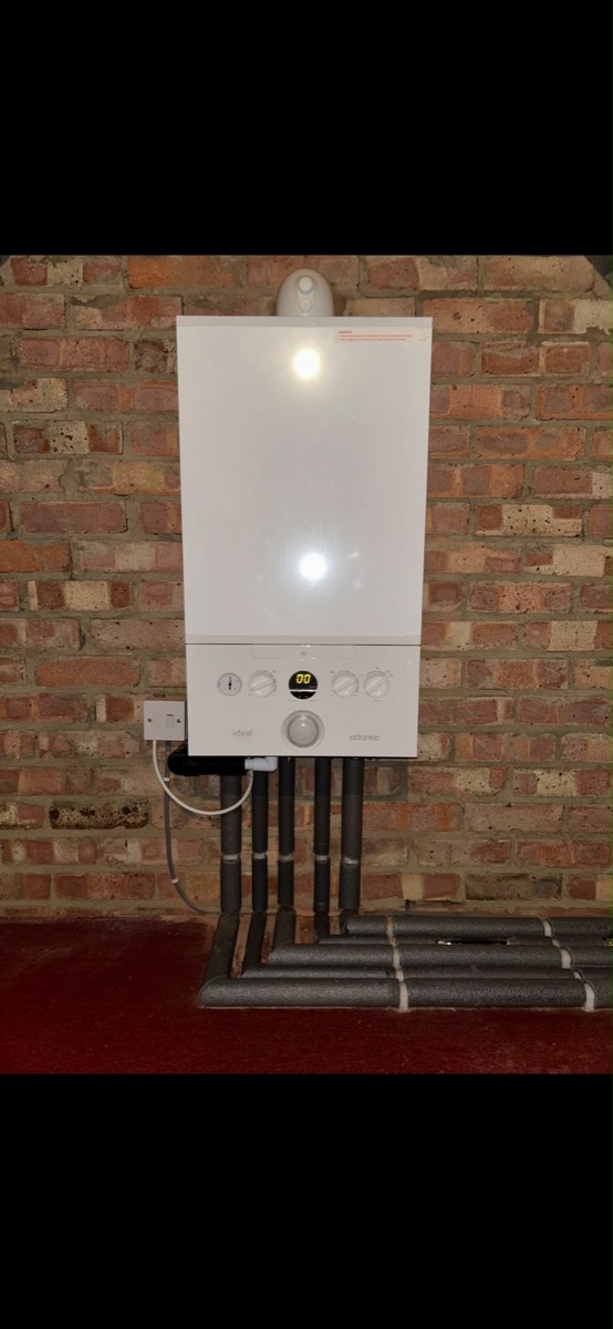 Ideal Atlantic boiler installed on an exposed brick wall with neatly insulated pipework