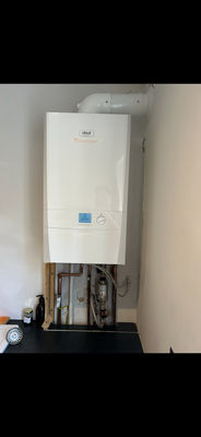 Boiler installation with new flue and exposed copper pipework, mid-job
