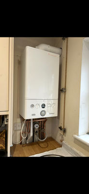 White combi boiler installed inside a cupboard