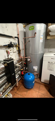 Unvented hot water cylinder installation with a blue expansion vessel and copper manifold