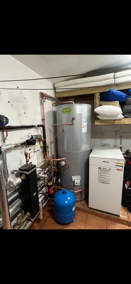 Unvented Joule Cyclone hot water cylinder beside a Worcester floor-standing boiler, with copper pipework and a blue expansion vessel